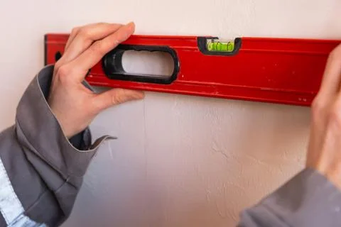 Checking wall alignment using level, surface preparation before installatio.. 写真素材
