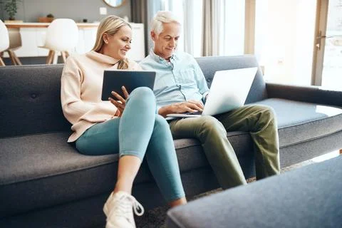 Checking what hes browsing to browse the same. mature couple using a laptop on Stock Photos