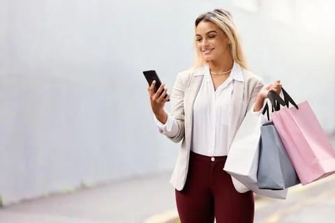 Checking where the next big sale is. an attractive young woman texting while out Stock Photos