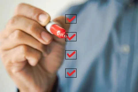 Checklist concept, Businessman checking mark on the check boxes using red mar Stock Photos