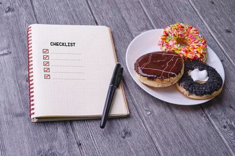 Checklist concept - checklist box with red checkmark, paper, doughtnut and a Stock Photos