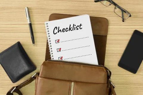 Checklist word written on notebook placed inside a men's leather bag. Stock Photos