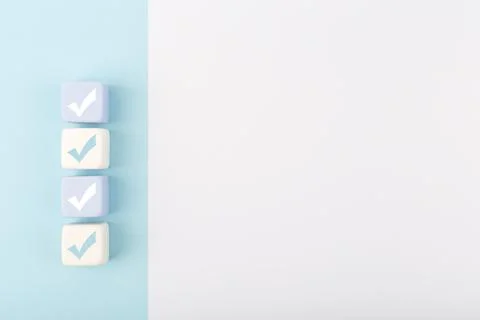 Checkmarks on four light toy blocks against white background with copy space Stock Photos