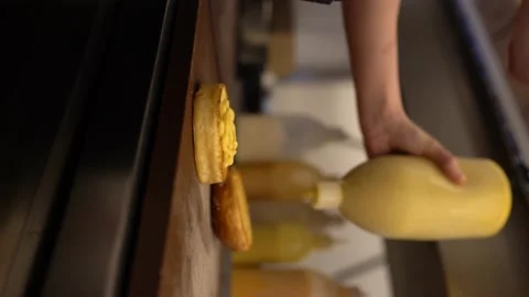 Cheddar sauce is squeezed between the hamburger buns Stock Footage 196140856