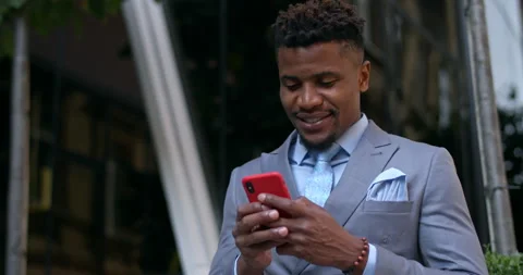 Cheeerful afro american guy in suit and tie communicating and smiling while Video stock 130380051