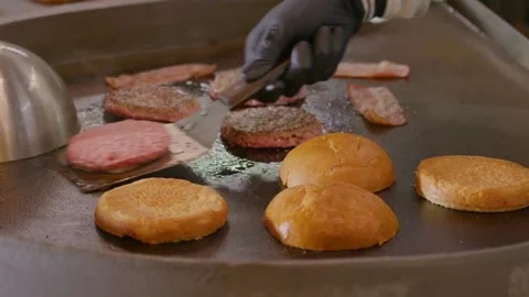 The Cheef is salting roasting burgers and buns for burgers. Cook's Hands. Stock Footage