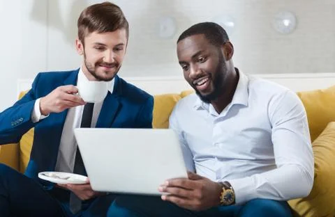 Cheeful colleagues using laptop Stock Photos