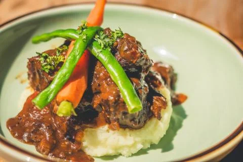 Cheeky Git Braised beef cheek stew with french beans and housemade mash Stockfoto's