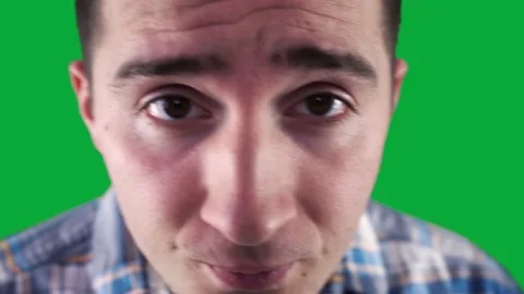 Cheeky guy in a shirt twitches at the camera on the background of a green screen Stock Footage 161316355
