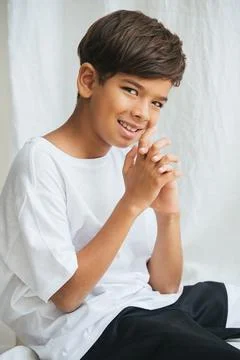 Cheeky indian boy sitting on a table, looking at the camera Stock Photos