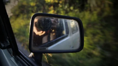 Cheeky rear view mirror shot with camera in driving car through Laos Stock Footage 104121245