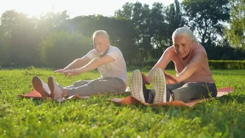 Cheerful aged couple doing stretching exercises outdoors Stock Footage 80278335