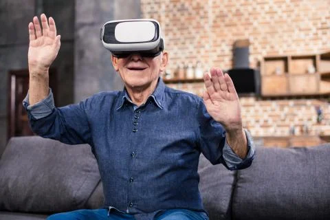 Cheerful aged man testing VR device Stockfoto's