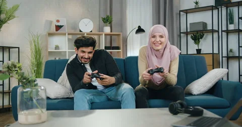 Cheerful amusing attractive young multiethnic couple enjoying video games and Stock Footage 150122840