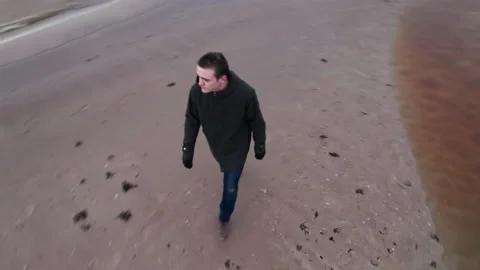 A cheerful and cheerful young guy in simple dark clothes walks Stock Footage 172172900