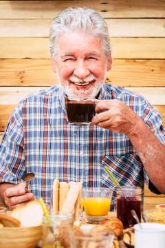 Cheerful and funny active nice senior man drinking hot chocolate with beard a Fotos Stock