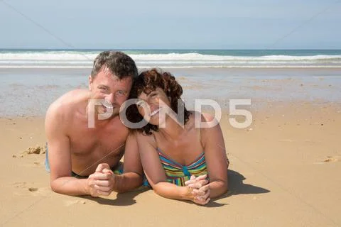 Cheerful and loving Couple on beach smiling at the camera Stock Photos