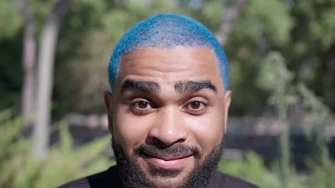 Cheerful and smiling black bearded man with blue hair making faces 스톡 동영상 287488079