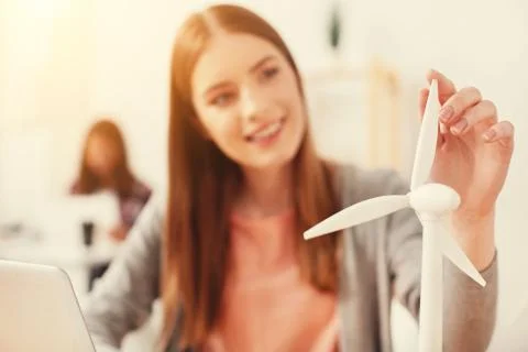 Cheerful architect looking at the model of a wind turbine Foto stock
