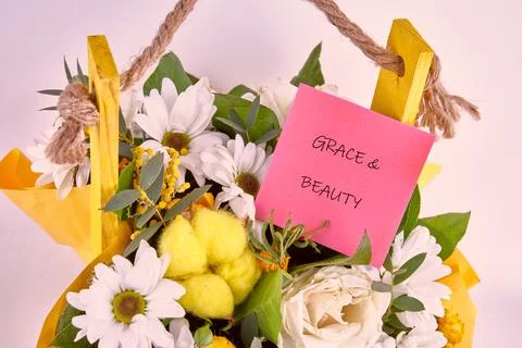 A cheerful array of white daisies, creamy roses, and sunny yellow accents spills Stock Photos