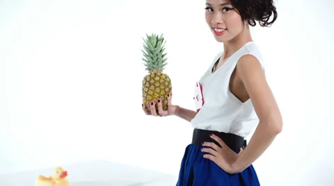 Cheerful asian model with pineapple and yellow duck posing in studio 動画素材 39809507