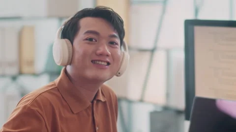 Cheerful Asian Programmer in Headphones Working on Computer Stock Footage 265071652