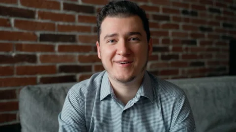 Cheerful attractive man looking at camera, talking and waving with hand Stock Footage 152905360