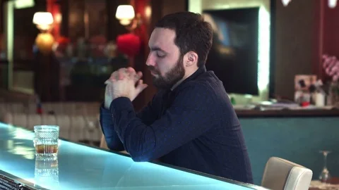 Cheerful attractive young man drinking in in a bar and look at camera smiling Vídeos de archivo 76601332