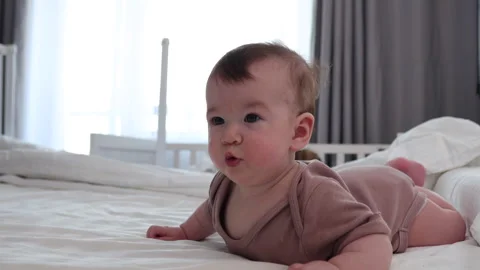A cheerful baby on a big bed Video stock 330180700