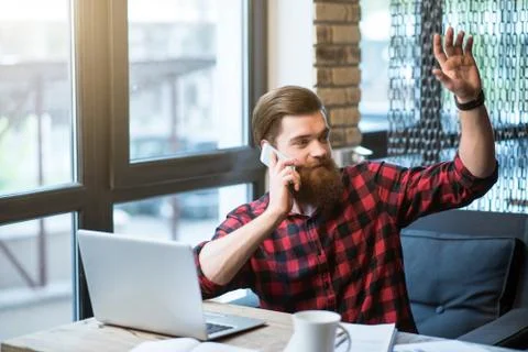 Cheerful bearded man sitting at the table Stock Photos