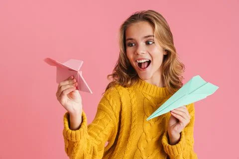 Cheerful beautiful blonde girl smiling and throwing paper planes Stock Photos