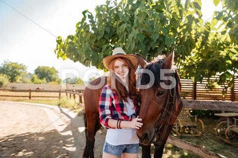 Cheerful beautiful young woman cowgirl with her horse Stock Photos