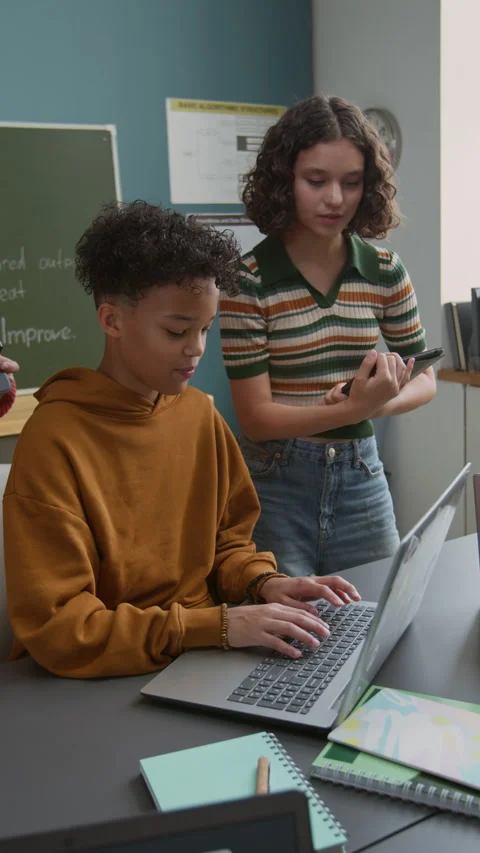 Cheerful Black Boy Writing Computer Code on Laptop and Classmate Watching Stock Footage 318719973