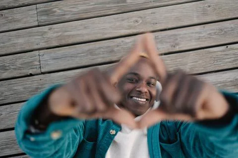 Cheerful black man makes frame sign with both hands looking to the camera with Stock Photos