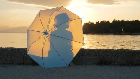 Cheerful boy of 5-6 yearls old walks along coastline with umbrella in his hands Stock Footage 121853890