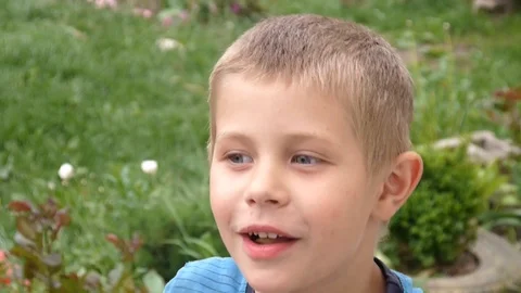 Cheerful boy bites an apple in the nature Stock Footage 89785923