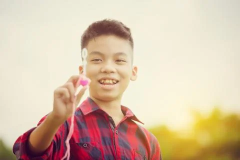 Cheerful a boy blowing soap bubbles in the park, Kids playing concept Stockfoto's