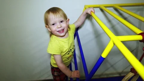 A cheerful boy crawls up and down the stairs, trains on sports gear Stock Footage 167176662