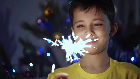 The Cheerful Boy Makes a Wish, Looking at a Christmas Bengal Light Stock-Footage 71228504