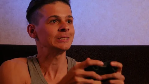 Cheerful boy playing in action game online with gamepad controller in hands Stock Footage 106370874