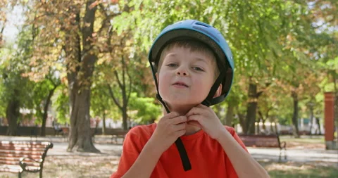 Cheerful boy puts on helmet preparing for riding bicycle Video stock 274140163