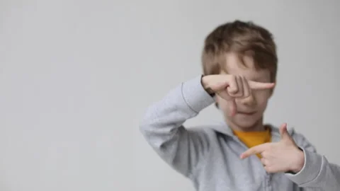 Cheerful boy smiling making frame with hands and fingers with happy face on w Stock Footage 169011760