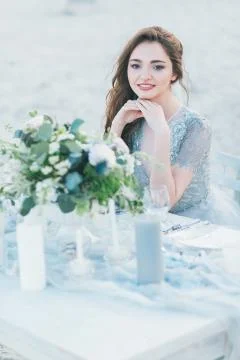 Cheerful bride by the table at the seashore 写真素材