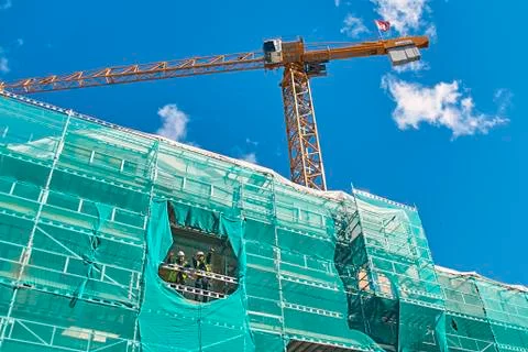 Cheerful builders workers gesture while working on the construction site Stock Photos