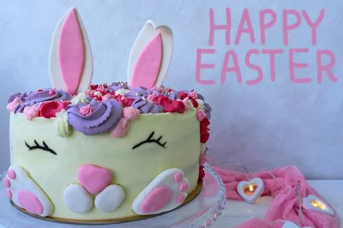 Cheerful bunny cake for Easter. Chalk lettering Happy Easter . Greeting card. Stock Photos