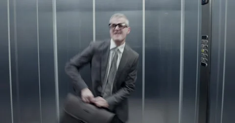 Cheerful businessman celebrating alone in the elevator Stock Footage 302974784