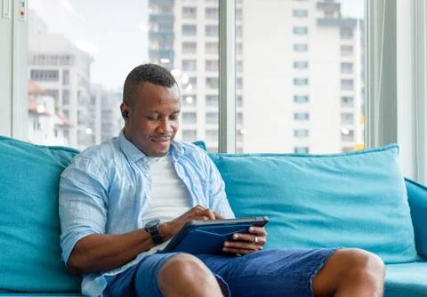 Cheerful casual man using digital tablet in living room, Happiness family 写真素材