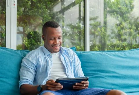 Cheerful casual man using digital tablet in living room, Happiness family Фото