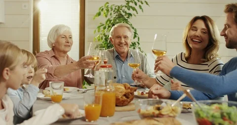Cheerful Caucasian family having lunch and doing cheers move with grandparents Stock Footage