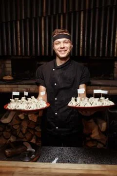 Cheerful chef posing with a serving of Khinkali. Georgian national traditional Stock Photos
